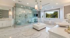 a large white bathroom with marble floors and walls