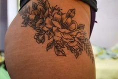 a woman's lower back tattoo with flowers on it