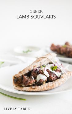 a white plate topped with a pita filled with meat