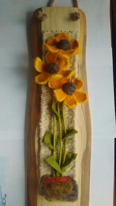 a piece of art made out of wood with sunflowers on it and dirt in the middle