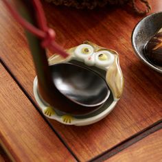 an owl shaped bowl and spoon on a table