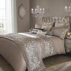 a large bed in a room with a chandelier on the headboard and pillows