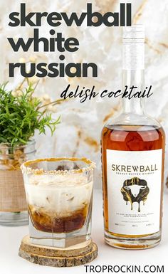 a bottle of white russian vodka next to a shot glass with ice and sprigs