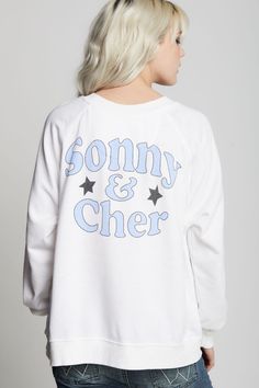 This sweatshirt is an absolute must have for any Sonny & Cher fan. The front features the duo's names and a photo graphic of the icons with their song "Bring It On Home To Me" below. "Sonny & Cher" is also featured on the back with stars. Made with vintage washed fabric, ribbed hems, a relaxed crew neckline, and an oversized fit. The design of this style is oversized. For a more standard fit, choose a size down. Details Style #302270 Color: White Sonny & Cher Bring It On Home To Me Oversized Swe White Screen Print Band Merch Sweatshirt, White Oversized Band Merch Sweatshirt, White French Terry Top With Graphic Print, Graphic Print French Terry Crew Top, French Terry Crew Top With Graphic Print, Graphic Print Crew Top In French Terry, Graphic Print Crew Neck Top In French Terry, White Letter Print Sweatshirt For Concert, Relaxed Fit Sweatshirt With Screen Print For Concert