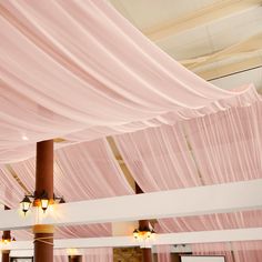 the ceiling is covered with pink drapes