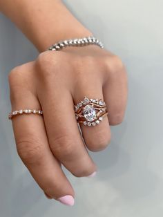 a woman's hand with two rings on her fingers and one ring in the middle