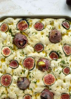 a pan filled with food covered in cheese and figs