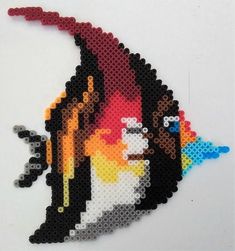 a piece of art made out of legos and beads on a white table top