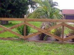 a wooden fence in front of a lush green yard