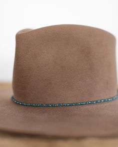 This hat band mixes beautiful faceted glass beads with brass accents to create a subtle sparkle to add to your hat. Material: Faceted glass beads & brass beads Dimensions: 21" beaded length Closure: Adjustable slide closure Color Options: Black, Gray, Beige, Blue Handmade by Crossbow in the mountains of Telluride, CO. Glass Hat, Beaded Hat Bands, Beaded Hat, Brass Beads, Belt Purse, Accessories Bags Purses, Crossbow, Brass Accents, Hat Band