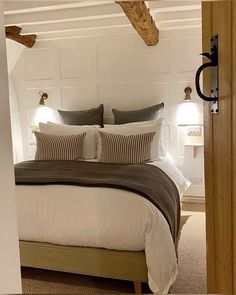 a bed sitting in a bedroom next to a wooden headboard and two lamps on either side of the bed