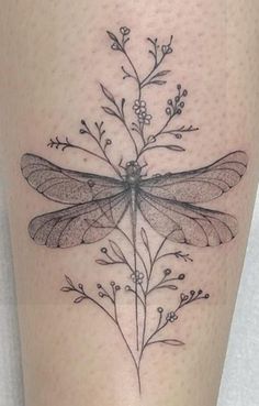 a black and white photo of a dragonfly on the leg with flowers in it