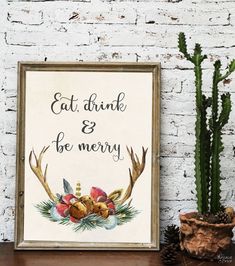 a sign that says eat drink and be merry next to a potted cacti