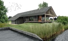 a house sitting on top of a lush green field next to a body of water