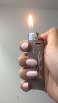 a person holding a lighter in their hand with pink nail polish on the thumbnails