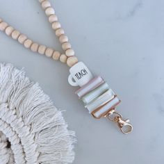 a white beaded necklace with wooden beads and a tassel hanging from it's end