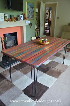 a wooden table sitting in front of a fire place with two apples on top of it