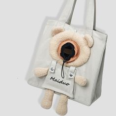 a teddy bear is attached to a white bag