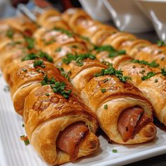 a white plate topped with rolls covered in meat and veggies on top of it