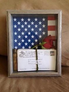 an american flag and two books in a shadow box on a couch with the caption's message