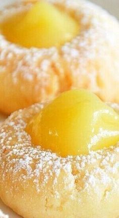 two pastries covered in powdered sugar with lemons on the top and bottom