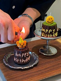 a person lighting a birthday candle on a cake