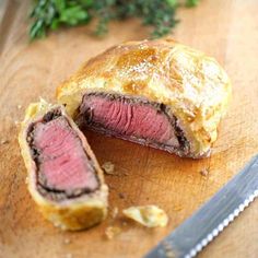 a piece of meat is cut in half on a cutting board