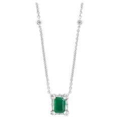 A fashionable pendant necklace showcasing a 0.99-carat emerald cut lush green emerald. The center stone is surrounded by a row of brilliant-cut 8 round and 8 baguette diamonds weighing 0.58 carats total. Made in 18k white gold. Comes with a gold chain accented with bezel set diamonds. Style available in different price ranges. Prices are based on your selection. Please contact us for more information. Emerald Cut Green Diamond Gemstone Necklace, Classic Green Necklace With Rectangular Pendant, Luxury Emerald Cut Emerald Necklace For Anniversary, Classic Green Diamond Pendant Necklace, Green Emerald-cut Diamond Necklace, Formal Emerald Cut Diamond Necklace, Green Pendant Diamond Necklace In Classic Style, Classic Green Pendant Diamond Necklace, Luxury Emerald-cut Emerald Diamond Necklace