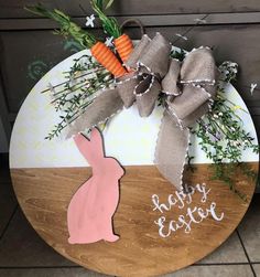 a wooden sign that says happy easter with a bunny and carrots tied to it