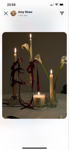 three candles with ribbons around them on a table