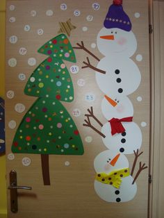 the door is decorated with paper snowmen and christmas trees, as well as numbers