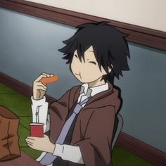 a person sitting at a table with a carrot in their hand