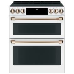 two white ovens side by side with gold knobs on the top and bottom