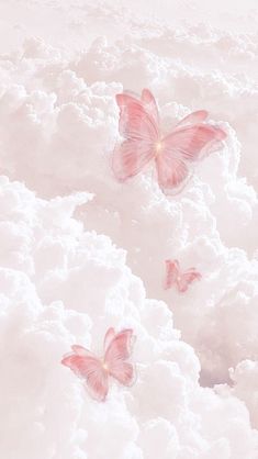 three pink butterflies flying in the sky above some white fluffy clouds with light colored highlights