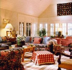 a living room filled with lots of furniture and flowers in vases on the table