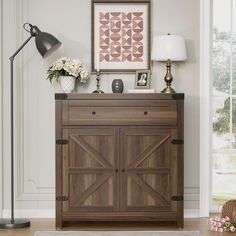 a living room with a wooden cabinet and lamp