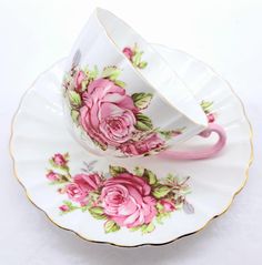 two cups and saucers with pink roses on them