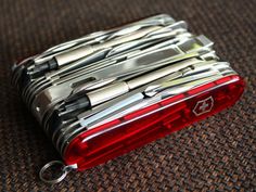 a red and silver lighter sitting on top of a carpet