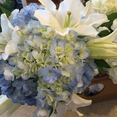 a bouquet of blue and white flowers sitting on top of a table