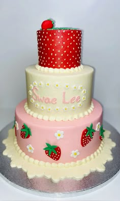 a three tiered cake decorated with strawberrys and polka dots