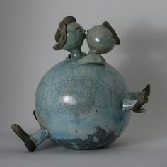 a blue vase with two birds on top