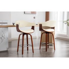 two modern barstools with wooden legs and white upholstered seats in front of a marble countertop