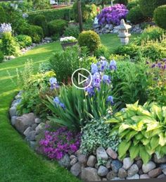 a garden filled with lots of different types of flowers and plants on top of green grass