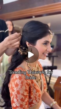 a woman is getting her hair done in an orange and white dress with gold accessories