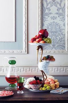 a table topped with plates and bowls filled with food next to a wine glass on top of a wooden table