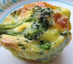 an omelet with broccoli and tomatoes on it sitting on a plate