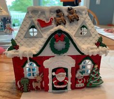 a small christmas house with decorations on the roof