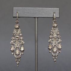 A dramatic and dazzling pair of Catalan drop earrings dating to the early 1800s. Known as 'herring' earrings due to the resemblance of their silhouette to herrings in brine, a popular dish of the region, they are set with a total of 74 diamonds, mainly rose- and table-cuts. The gems are set close-backed, some with crimped collets, and are most likely foiled. Each earring consists of five individually articulated sections which swing with movement and bring sparkle to the diamonds as they catch t Evening Diamond Chandelier Earrings, Victorian Rose Cut Diamond Earrings For Formal Occasions, Formal Rose Cut Diamond Chandelier Earrings, Formal Chandelier Earrings With Rose Cut Diamonds, Victorian Chandelier Drop Earrings With Intricate Design, Ornate Diamond Accent Drop Earrings, Fine Jewelry Rose Cut Diamond Earrings For Evening, Evening Diamond Earrings With Intricate Design, Diamond Earrings With Intricate Design For Evening