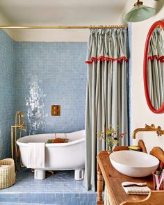 a bath room with a tub a sink and a mirror on the wall next to a window