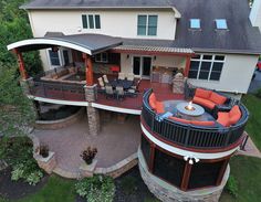 an aerial view of a house with patio and fire pit in the middle of it